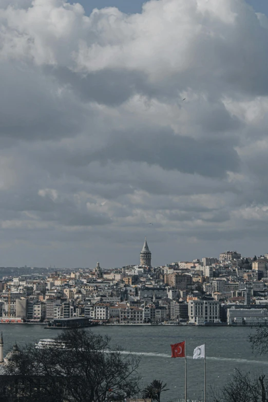 there are some clouds in the sky over a city by the ocean