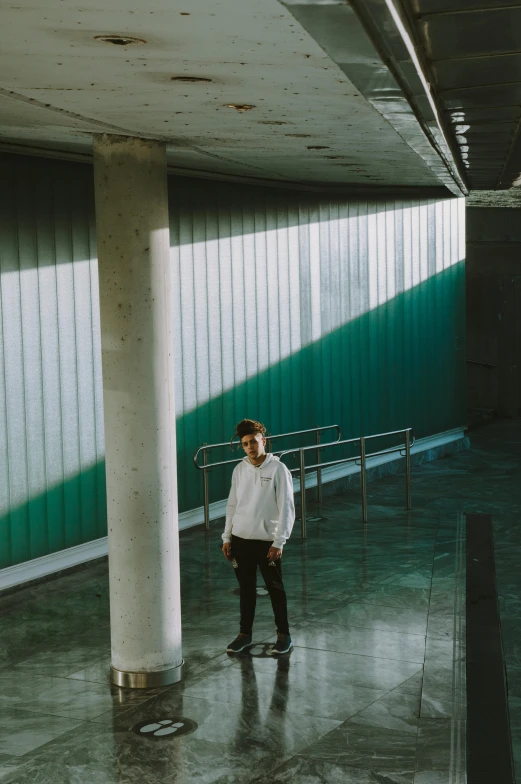 a man standing in a public area wearing a white jacket