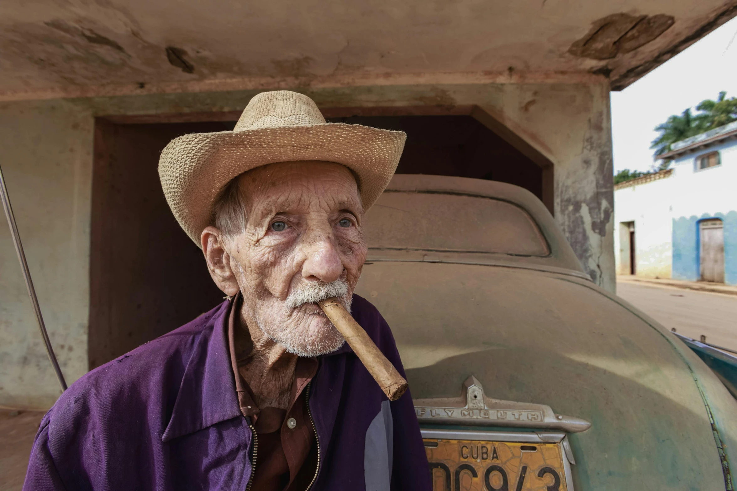 an old man with a cigar in his mouth sitting down