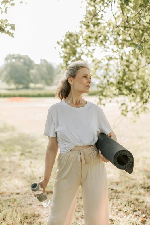 a woman carrying some yoga mat in her hands