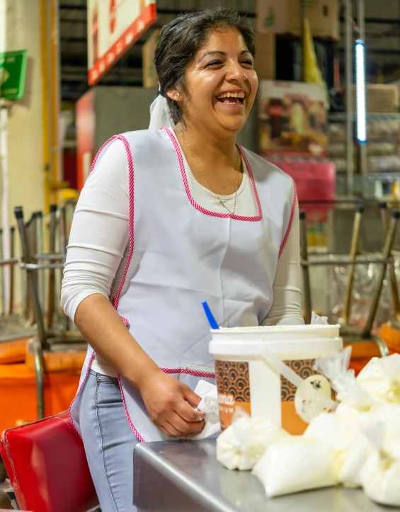 a woman working at a stand in a store smiling