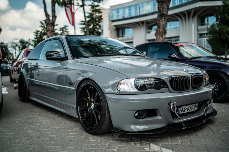 an all silver bmw on the street in front of parked cars