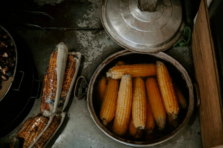 a pot with corn in it next to two bowls