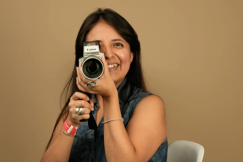 the woman is holding a camera and smiling