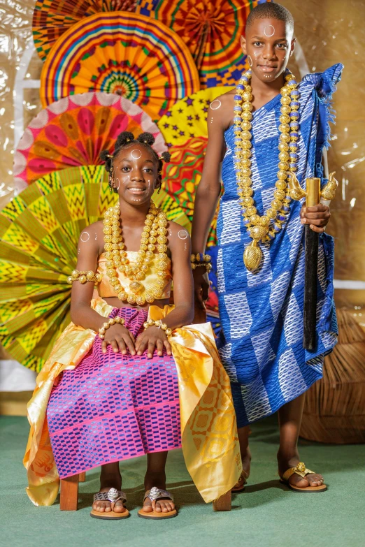 a boy and girl dressed in african attire