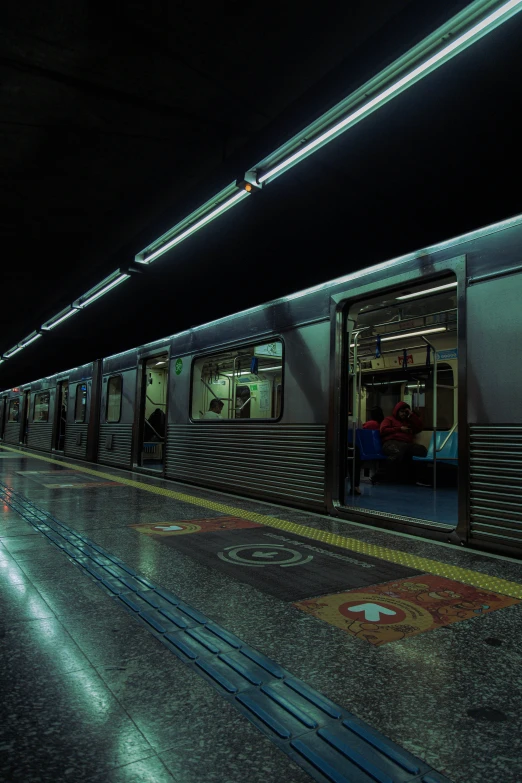 a dark subway train stopped at a subway stop