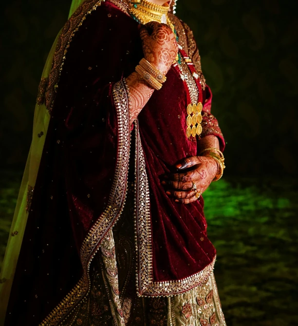 an indian woman wearing a red and gold bridal