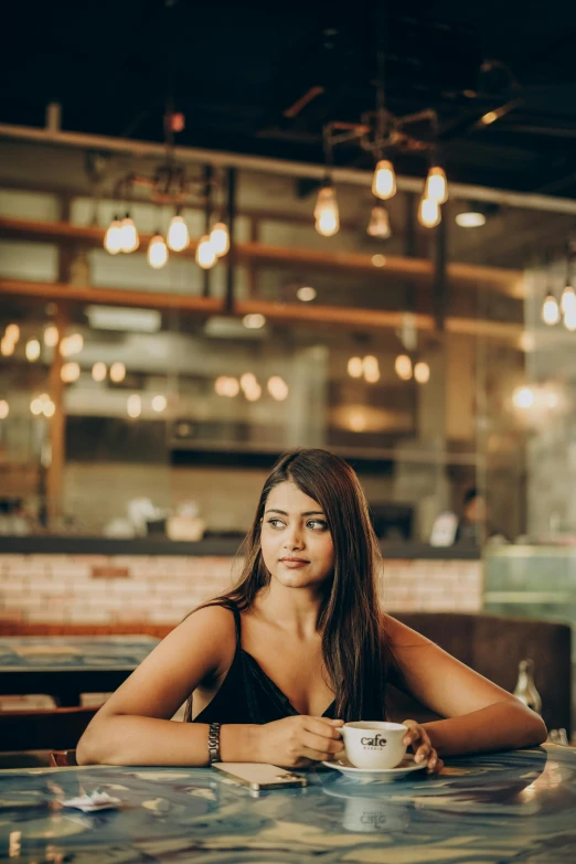 a woman sitting at a table with a coffee cup