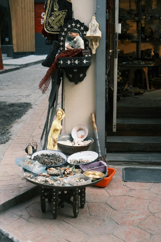 an assortment of dishes on display in front of a shop