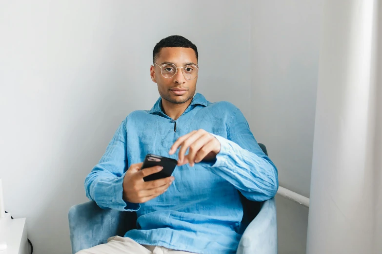 a man in blue shirt holding remote control