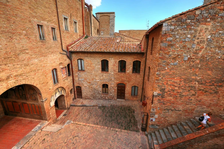 a red brick building with a red door, two women and stairs