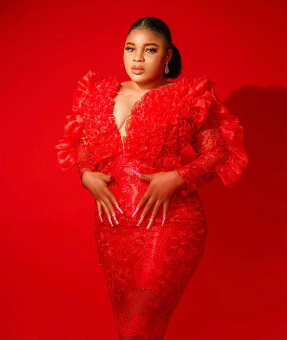 an african american woman in red poses for a portrait