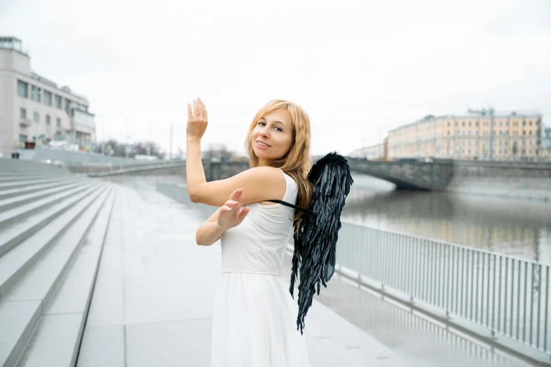 the woman is standing outside with her hands in the air