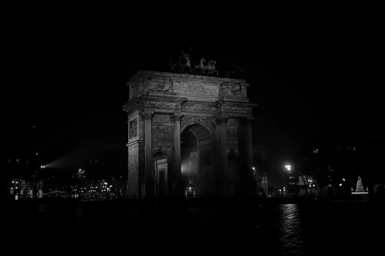 the gateway of a city in europe is lit up at night