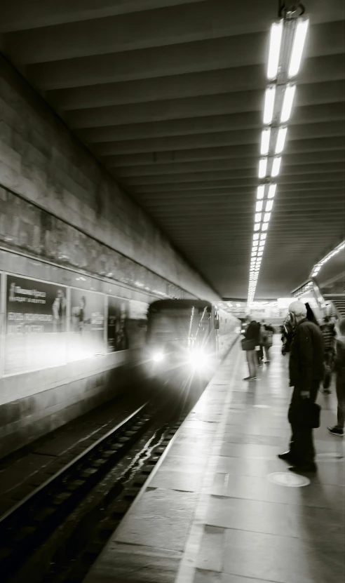 black and white po of people walking towards a subway train