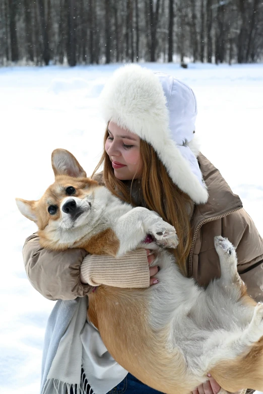 woman carrying a large brown dog while wearing a white hat