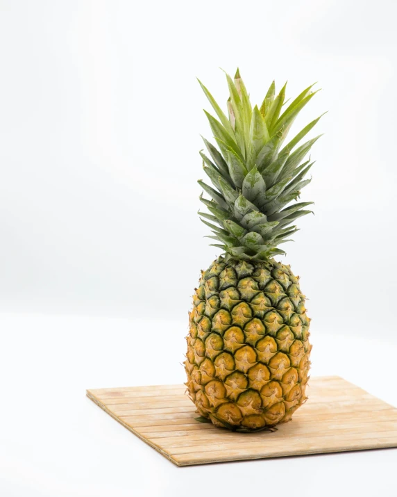 a large pineapple sitting on a wooden tray