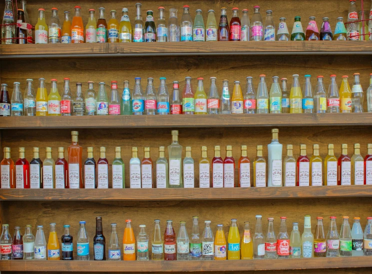 bottles of alcohol lined up on wooden shelves