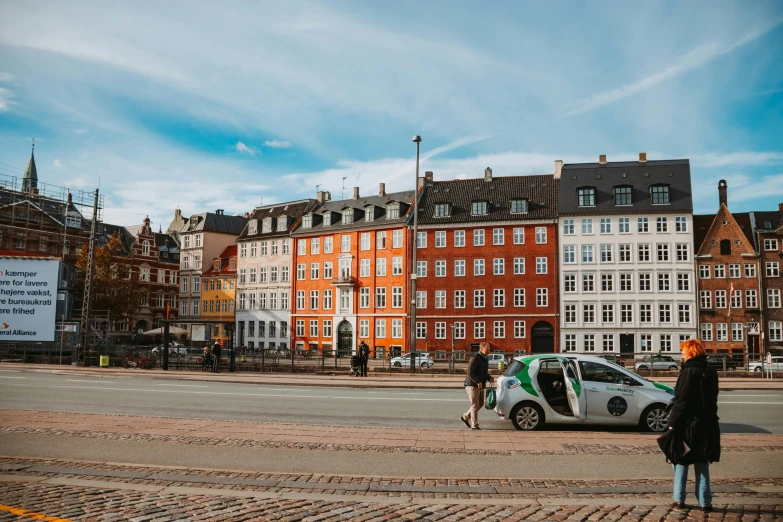 people walking on street with cars parked next to them