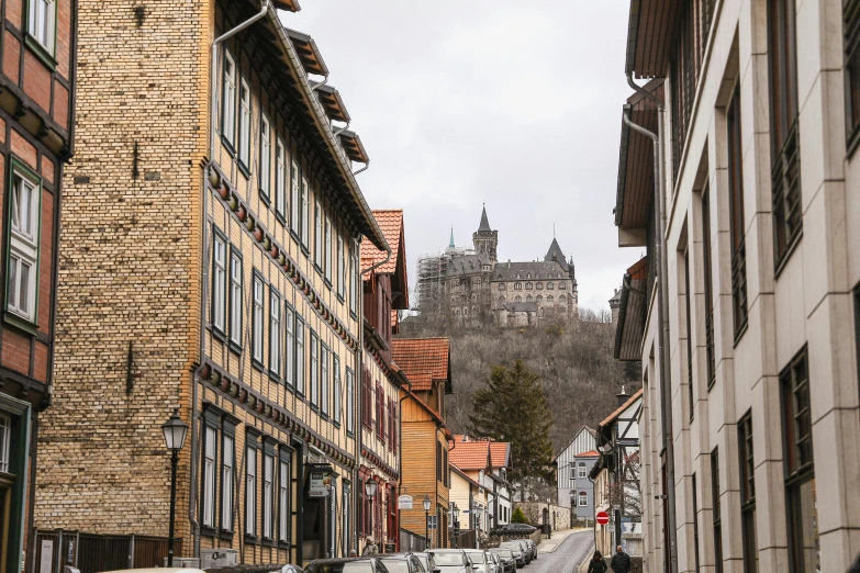 people are walking along a narrow city street