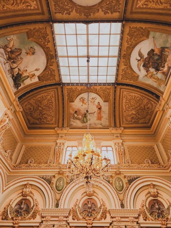 a chandelier hanging from a ceiling in a room with gold detailing