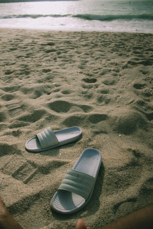 there is someones feet in the sand with shoes