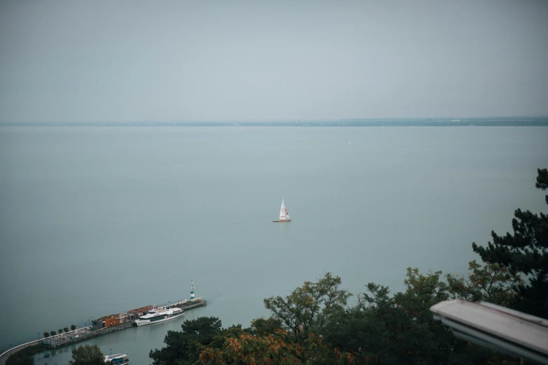 a boat sailing in the ocean next to a pier