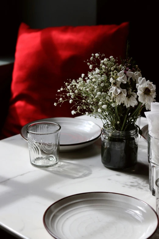 a white table setting with silver and silverware