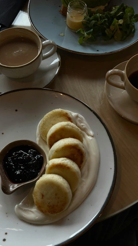 two plates topped with rolls and dipping sauce