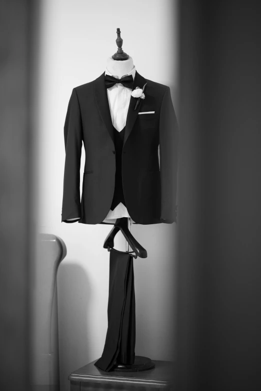 a suit and tie hang up on a clothes rack