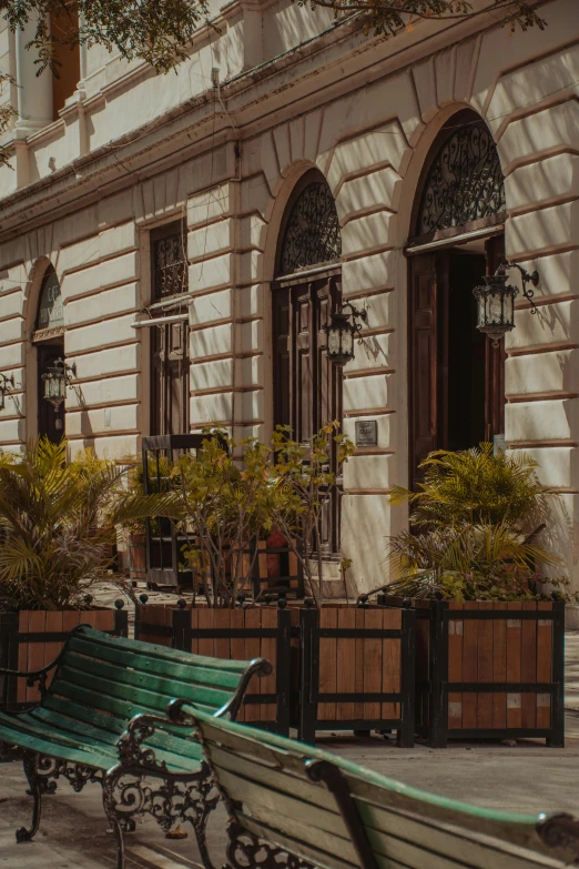 two benches on the street outside of a large building