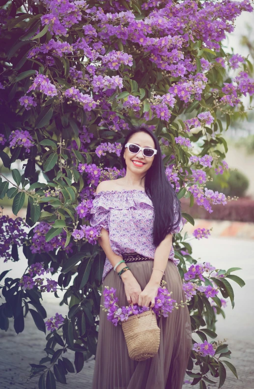 a beautiful woman poses in front of flowers