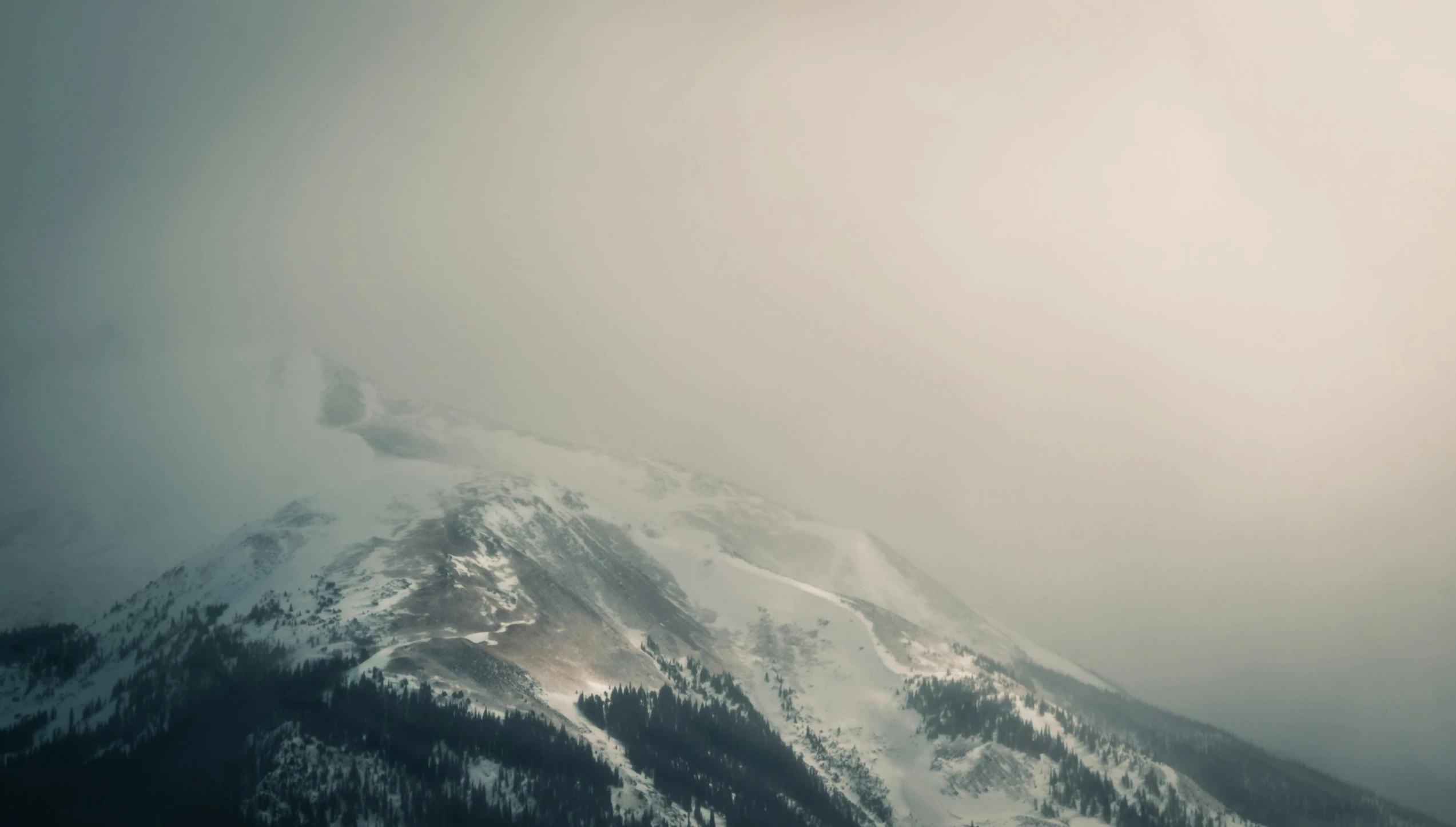 an airplane flying high over a snowy mountain range