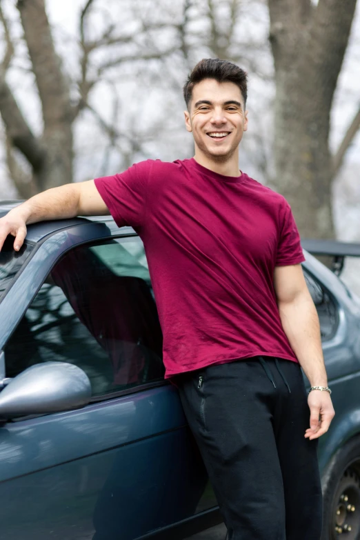 a man standing next to his car posing for the camera