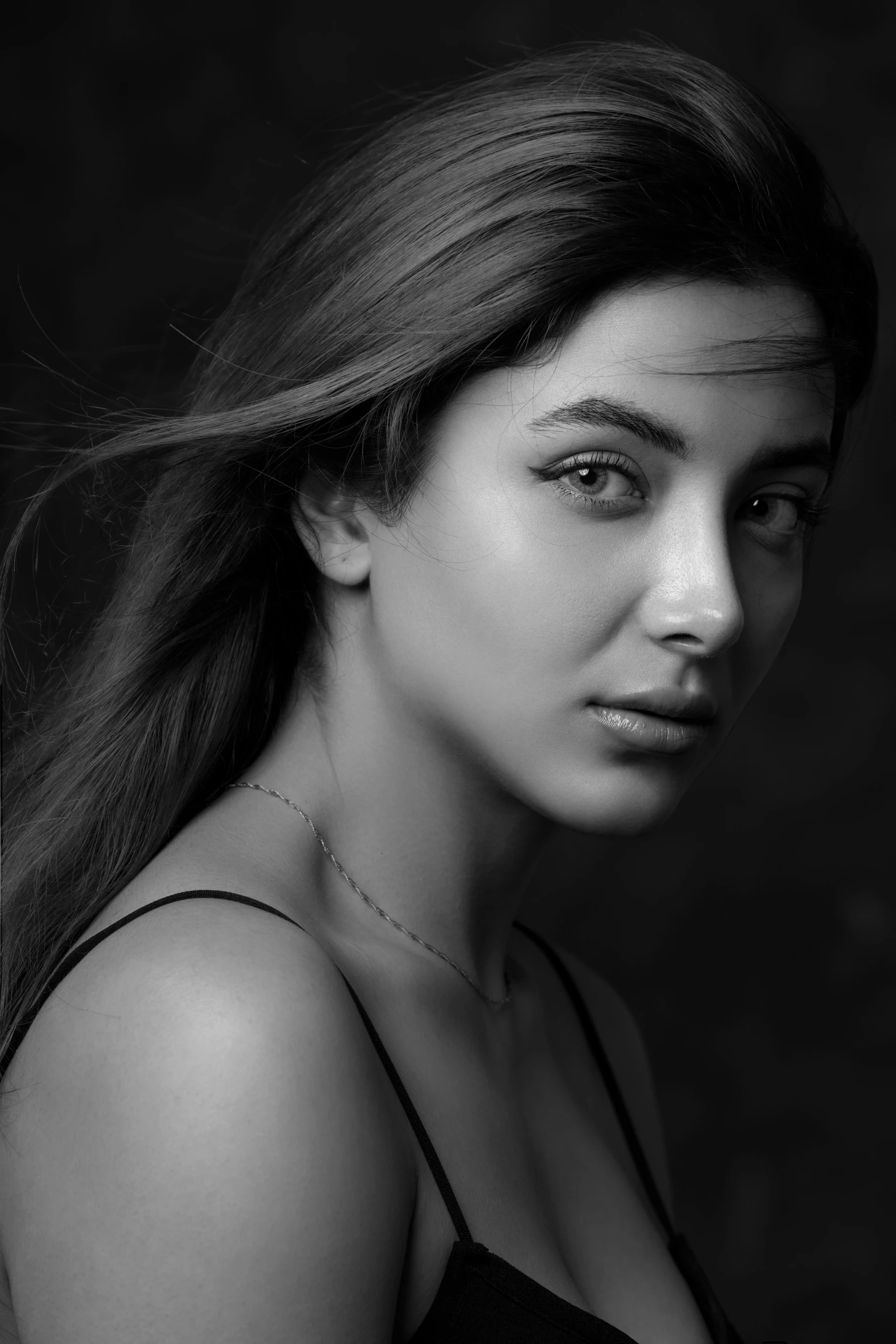 a woman wearing black is posing for a black and white picture