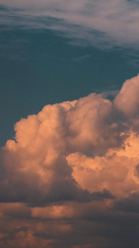 a group of clouds flying through a blue sky