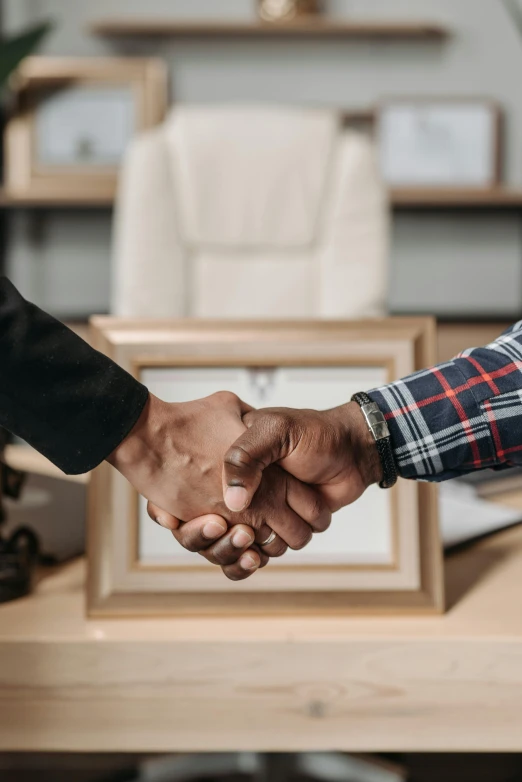 two men shake hands near a table