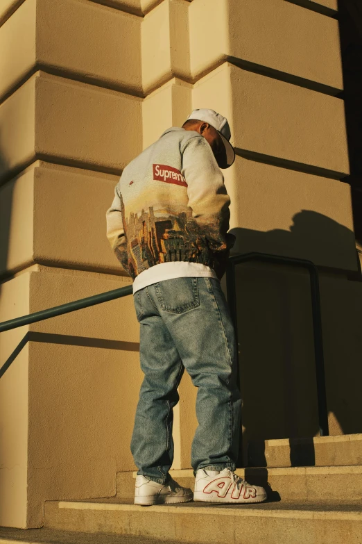 a skateboarder leans against the wall and looks over his shoulder