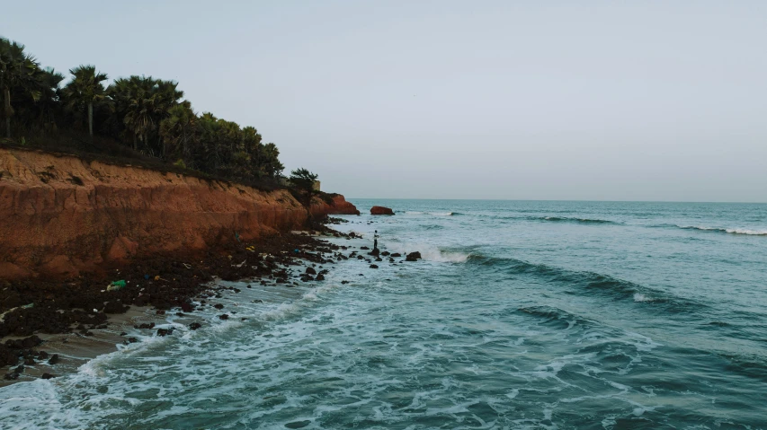 a large cliff sitting above the water in front of a body of water