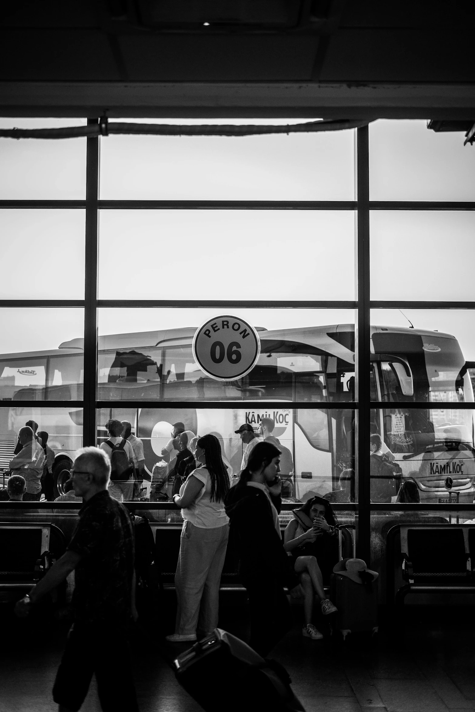 several people walking past luggage carts at an airport