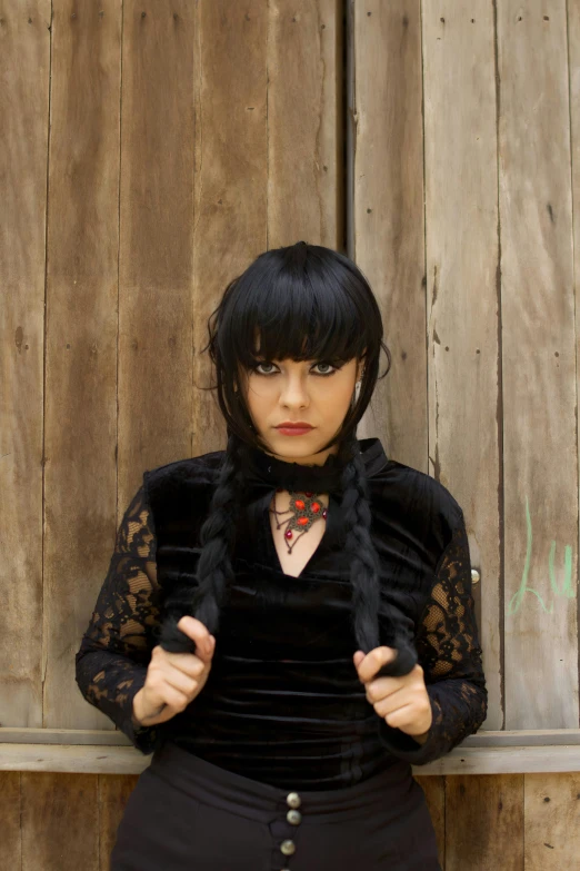 a woman in black is posing with a scarf