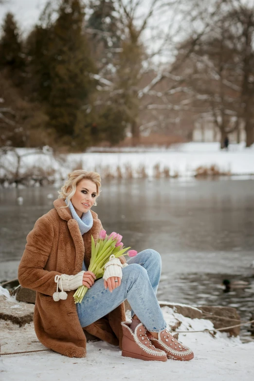 a woman is sitting on the bank with flowers