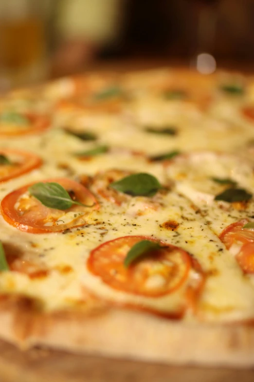 a whole pizza with several tomatoes, basil and garlic