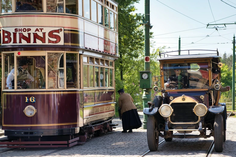 a double deckered trolley driving down a street past another