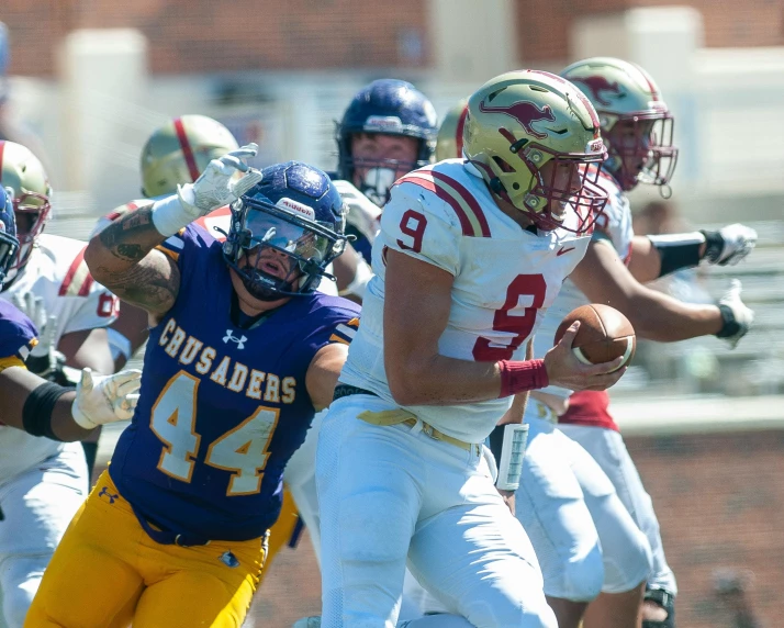 a football player holding a ball in one hand