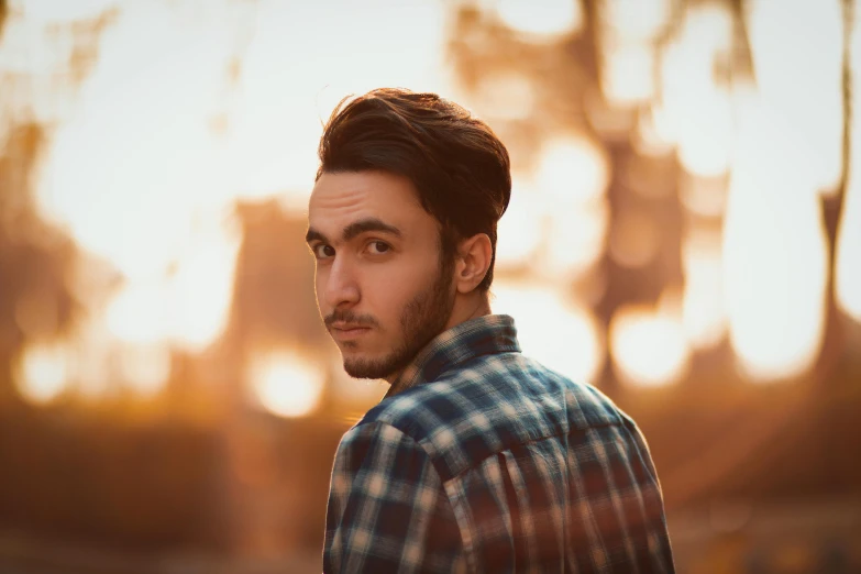 a man looking away from the camera during sunset