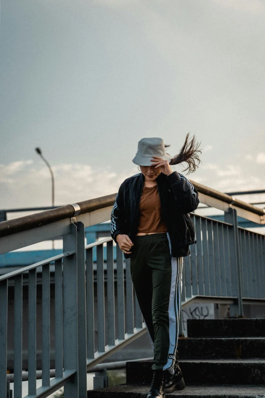 a woman walks down the flight of stairs while holding a bag