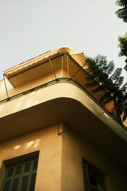 a side of an old yellow building with trees outside