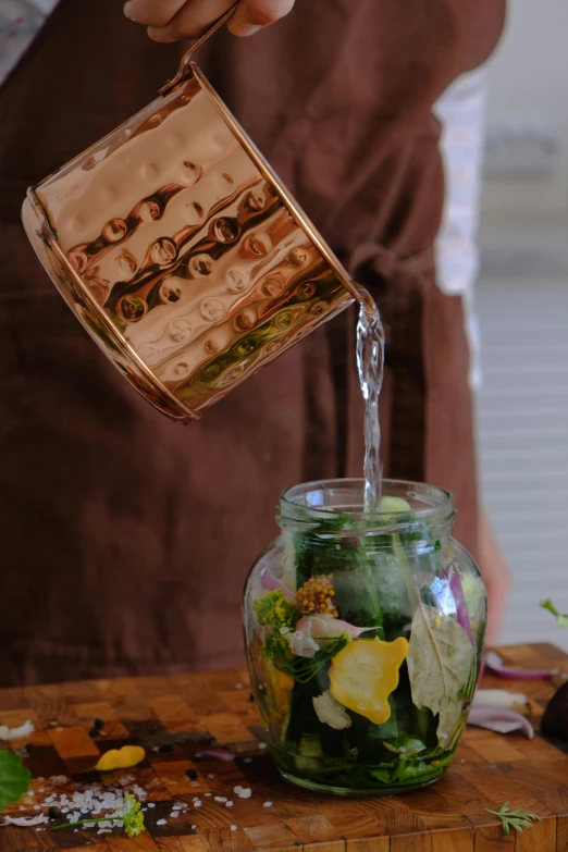 someone is pouring some water into a jar