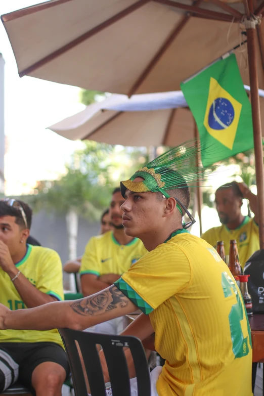 men sitting around at a table and under umbrellas with zil flag on it